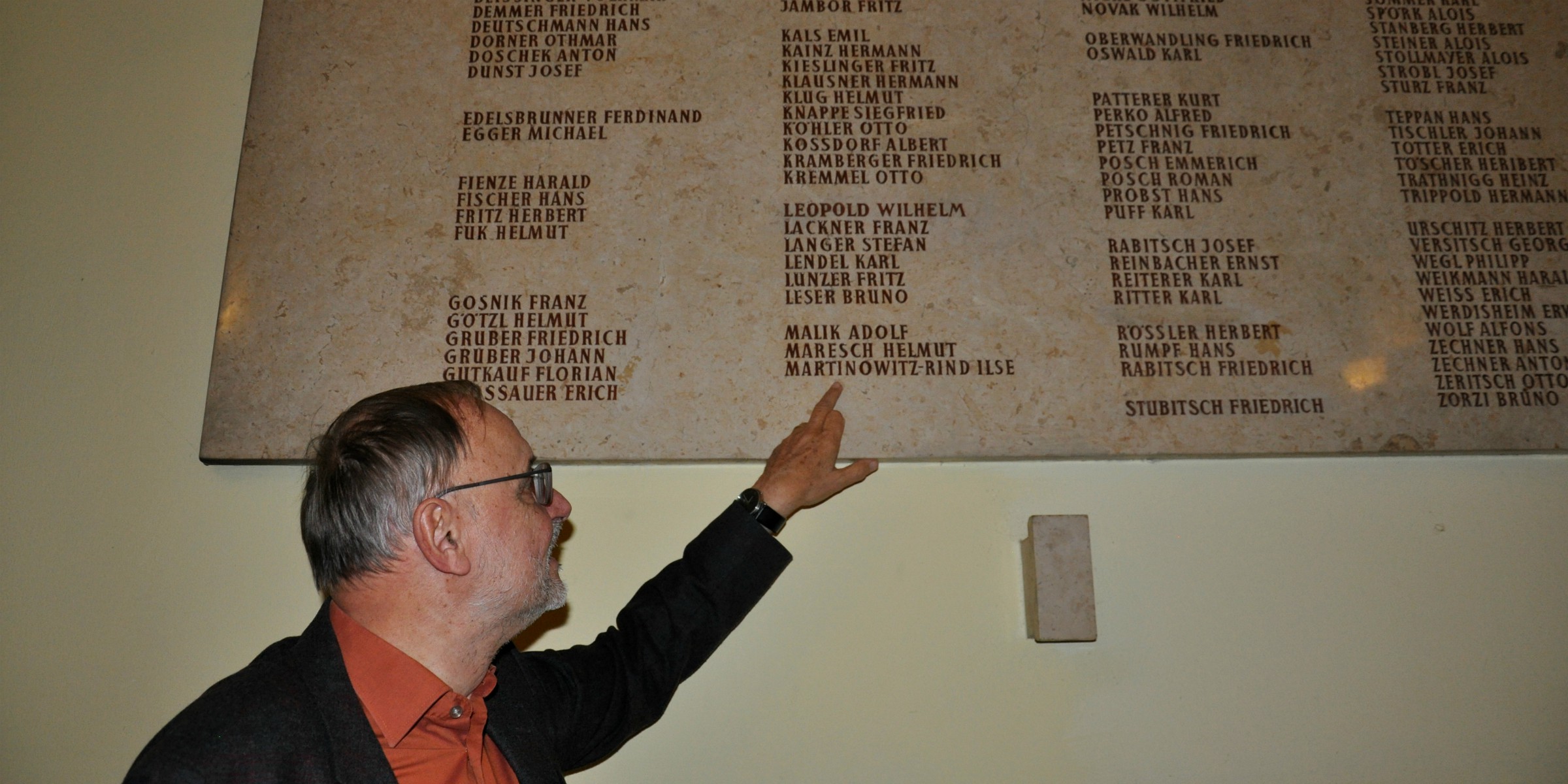 Direktor Dragaric zeigt eine Gedenktafel für Gefallene aus dem 2. Weltkrieg.