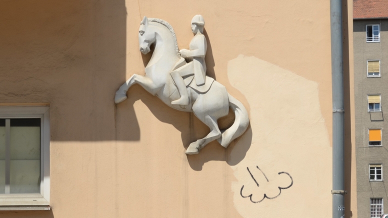 Relief von einem springenden Pferd mit Reiter, beim Hintern des Pferdes ist eine Gaswolke eingezeichnet