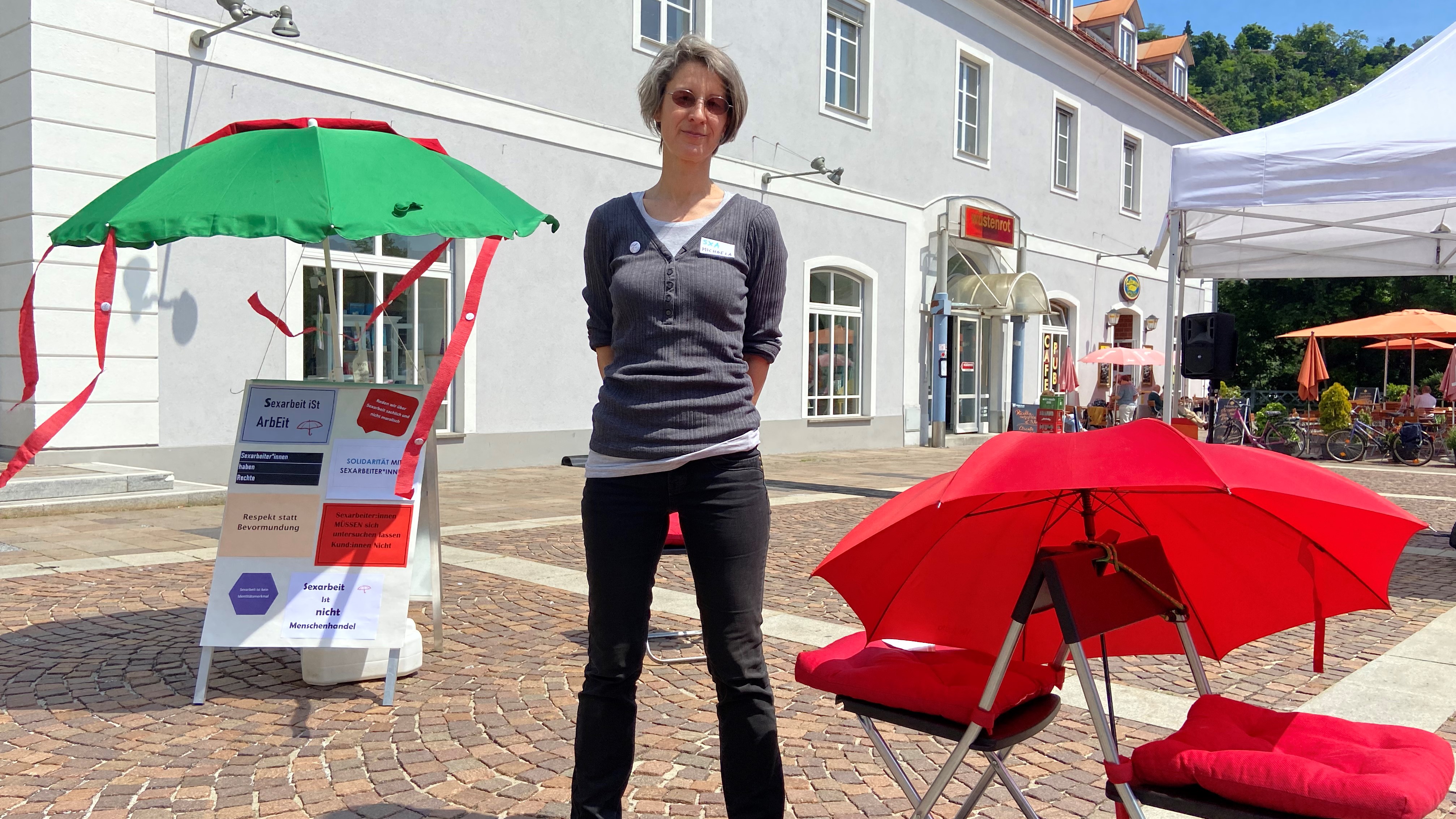 Michaela Engelmaier steht neben Schirmen. Sie leitet das Info-Projekt SeXArbeit für Sexarbeiterinnen
