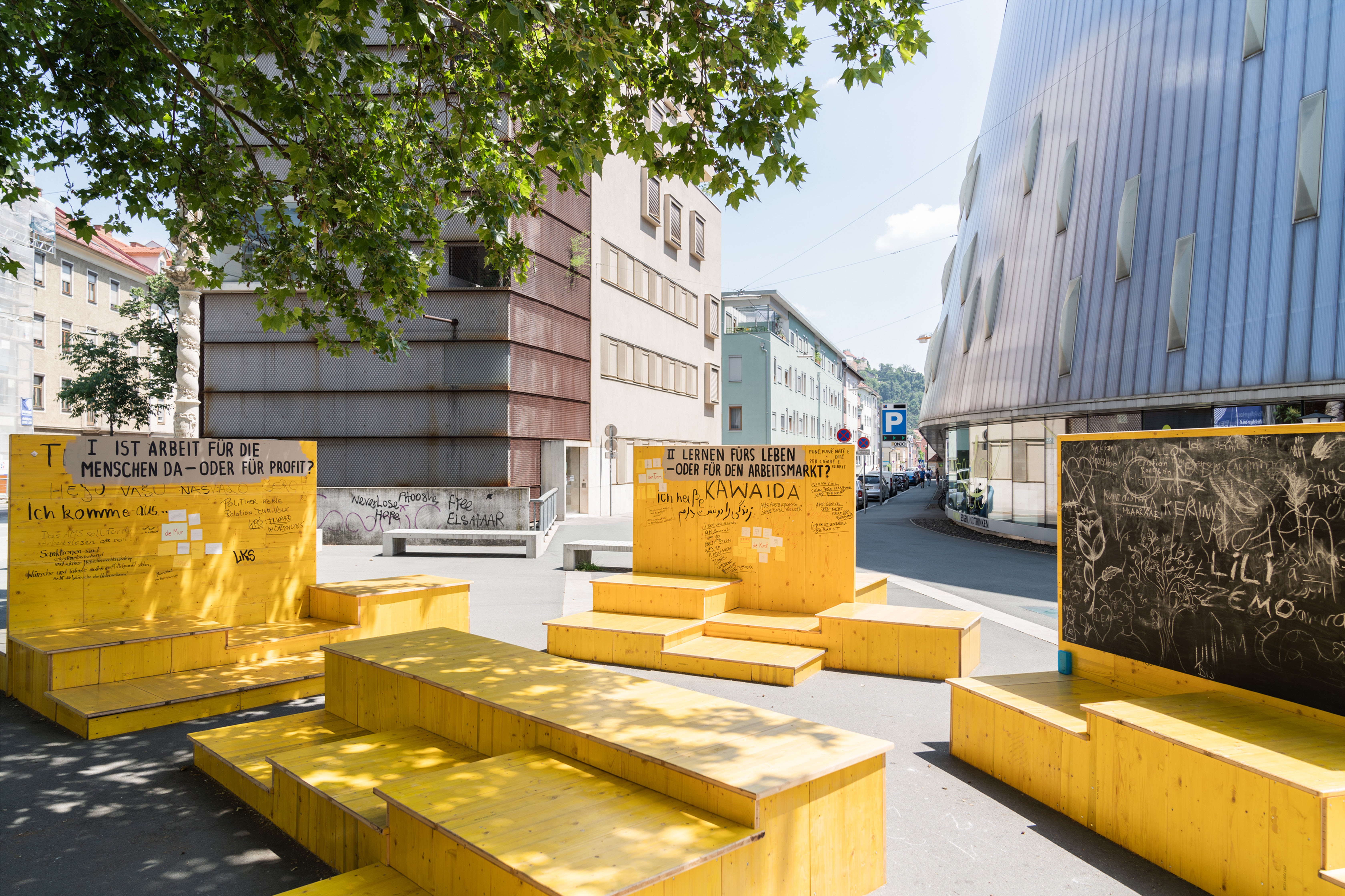 Gelbe Sitzflächen der Schule des Wir am Marienplatz