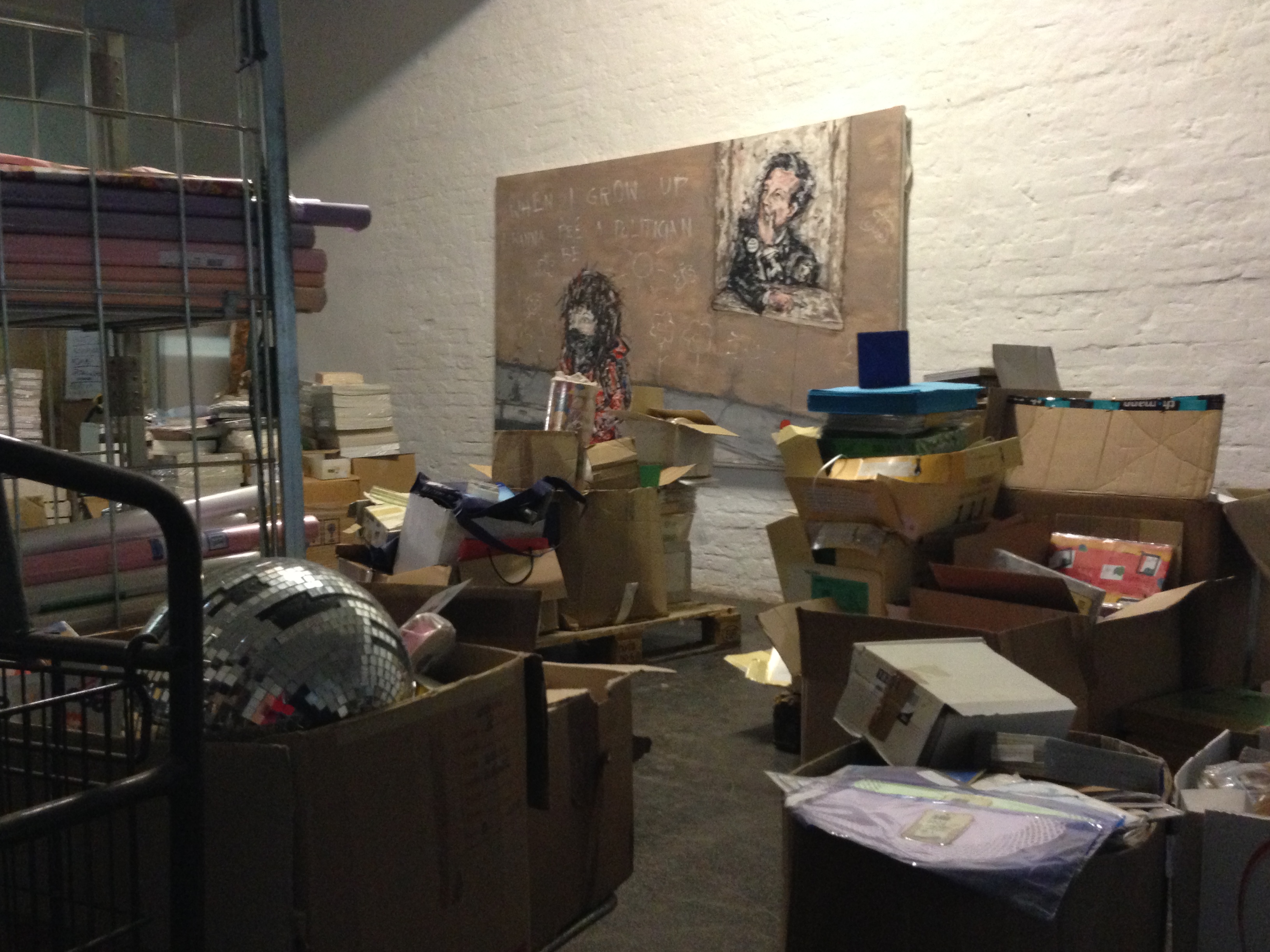 Vereinzelt hängen noch Kunstwerke der letzten Ausstellungen an den Wänden. Die Discokugel im Vordergrund hat vor einem Jahr noch eine Aufgabe gehabt. Jetzt wartet sie mit den anderen Flohmarktutensilien auf einen Käufer.
