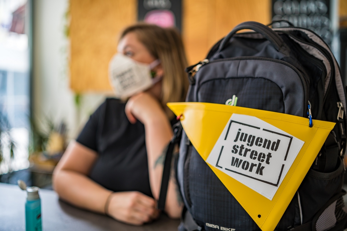 Frau mit Maske, Rucksack, Jugendstreetwork Graz