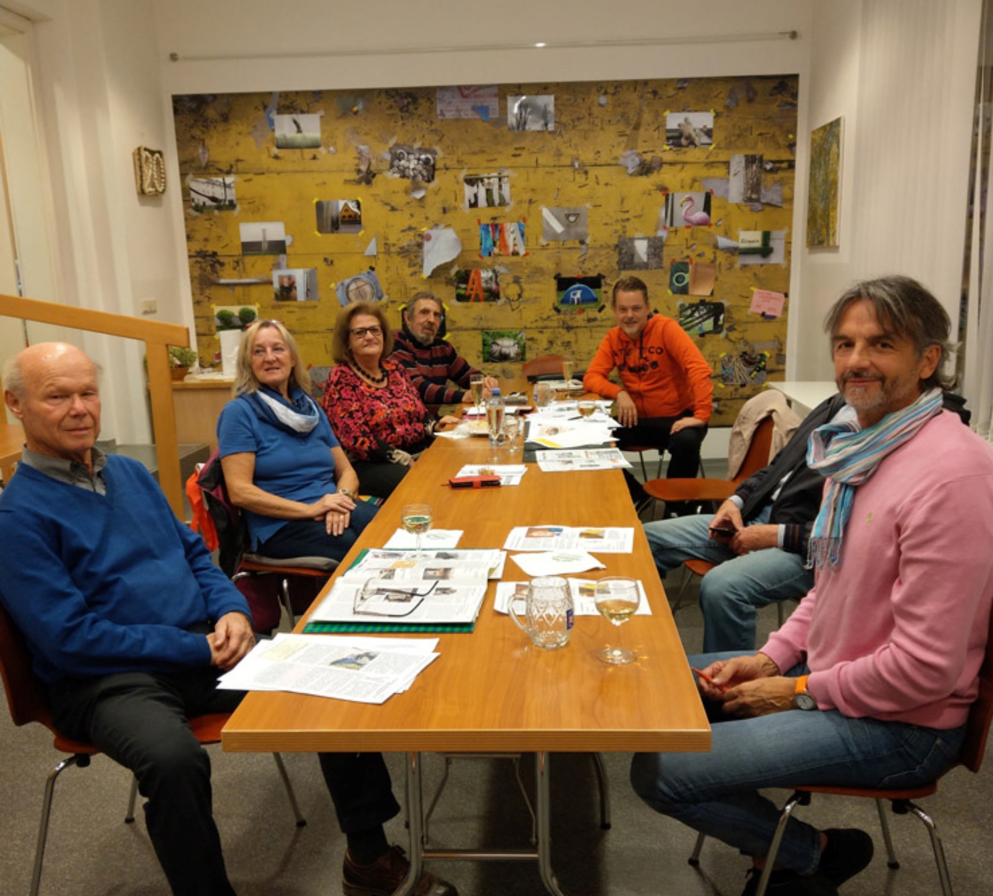 Redaktionssitzung der Stadtteiilzeitung; Sieben Leute sitzen um einen länglichen Tisch mit Notizen verteilt