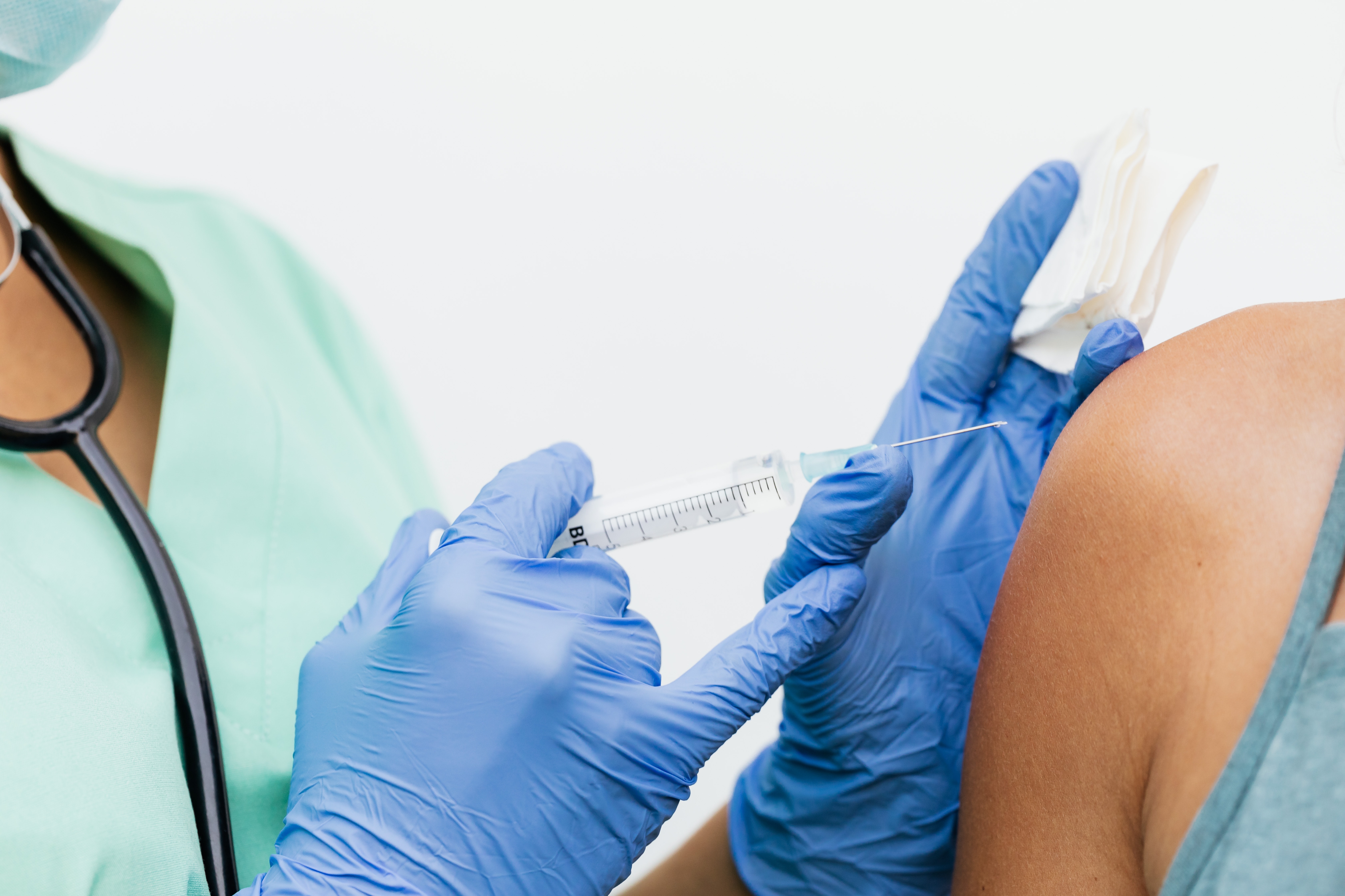 Eine Pflegekraft impft eine Patientin.