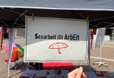 "Sexarbeit ist Arbeit", steht auf einem Schildchen. Ein roter Regenschirm ist daruntergemalt