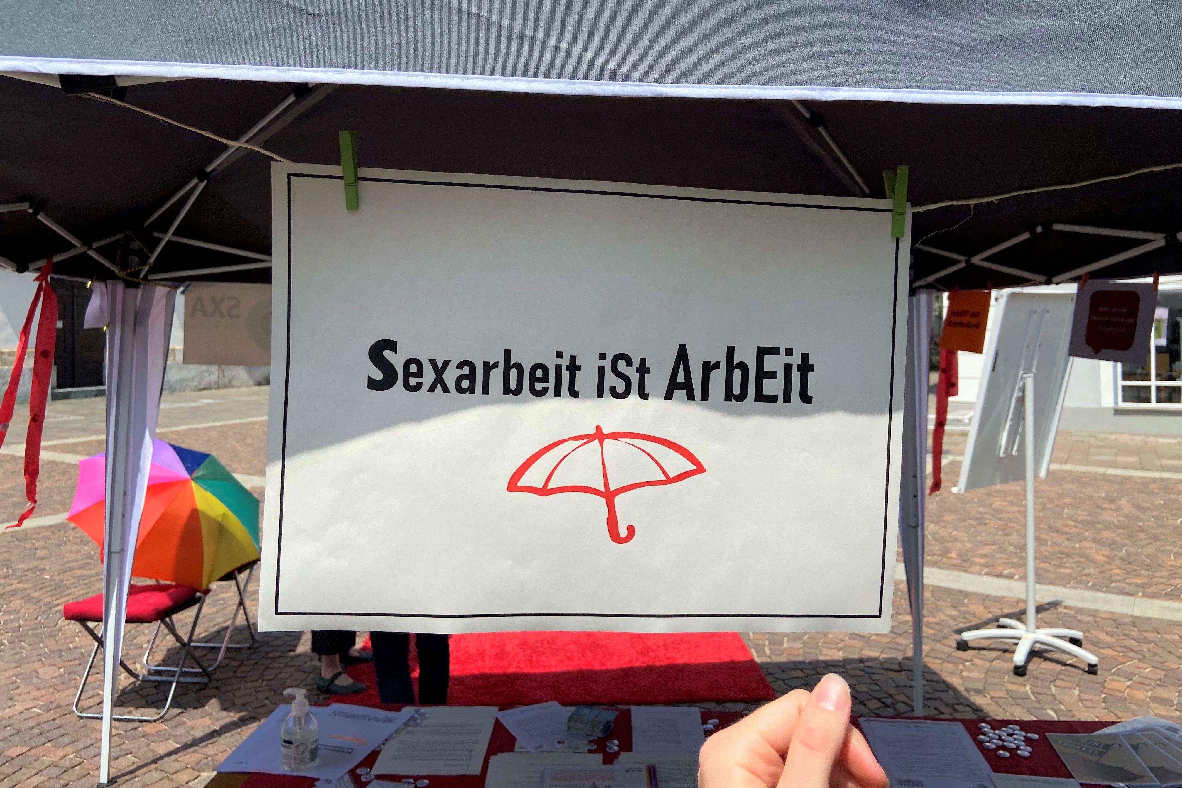 "Sexarbeit ist Arbeit", steht auf einem Schildchen. Ein roter Regenschirm ist daruntergemalt