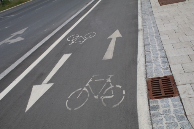Radweg neben der Straße mit zwei Radweg-Bodenmarkierungen