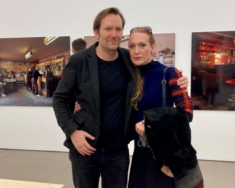 links ist Rainer Frimmel zu sehen, rechts Tizza Covi. Sie befinden sich im Ausstellungsraum der Camera Austria, im Hintergrund sieht man Bilder aus Wien.