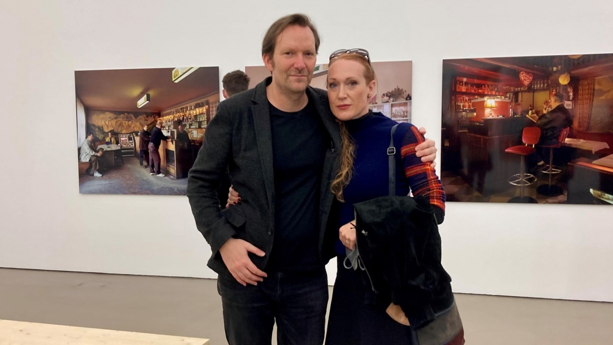 links ist Rainer Frimmel zu sehen, rechts Tizza Covi. Sie befinden sich im Ausstellungsraum der Camera Austria, im Hintergrund sieht man Bilder aus Wien.