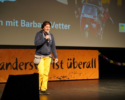 Barbara Vetter steht auf der Bühne im Orpheum und hält ein Mikrofon in der Hand.