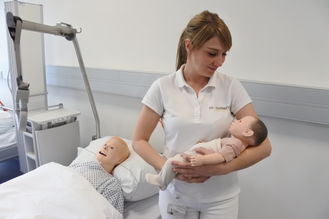Isabella Sumerauer zeigt an einer Simulationspuppe, wie man ein Baby richtig hält