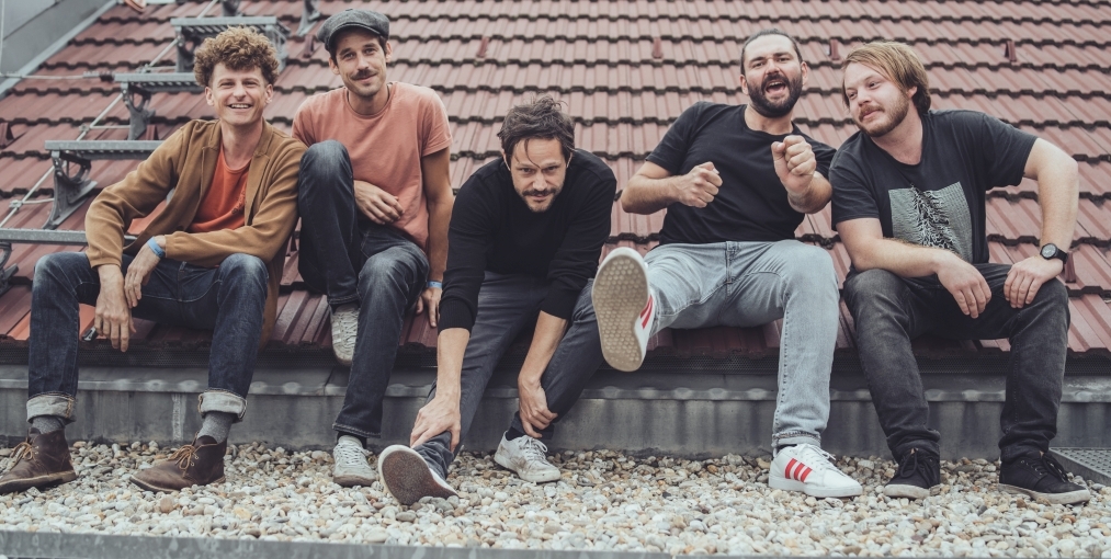Die Bandmitglieder von Granada sitzen nebeneinander