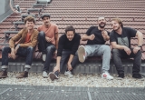 Die Bandmitglieder von Granada sitzen nebeneinander