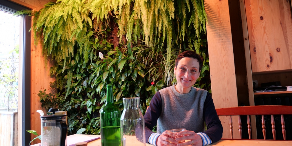 Franziska Schruth sitzt vor einer Pflanzenwand