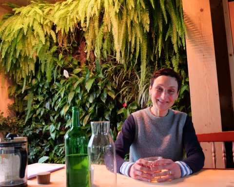 Franziska Schruth sitzt vor einer Pflanzenwand