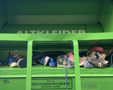 Grüner Container mit Kinderschuhen