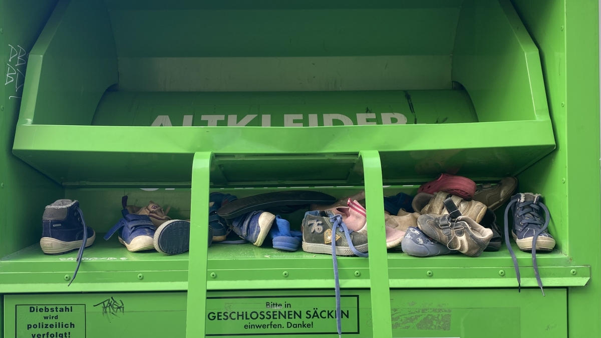 Grüner Container mit Kinderschuhen