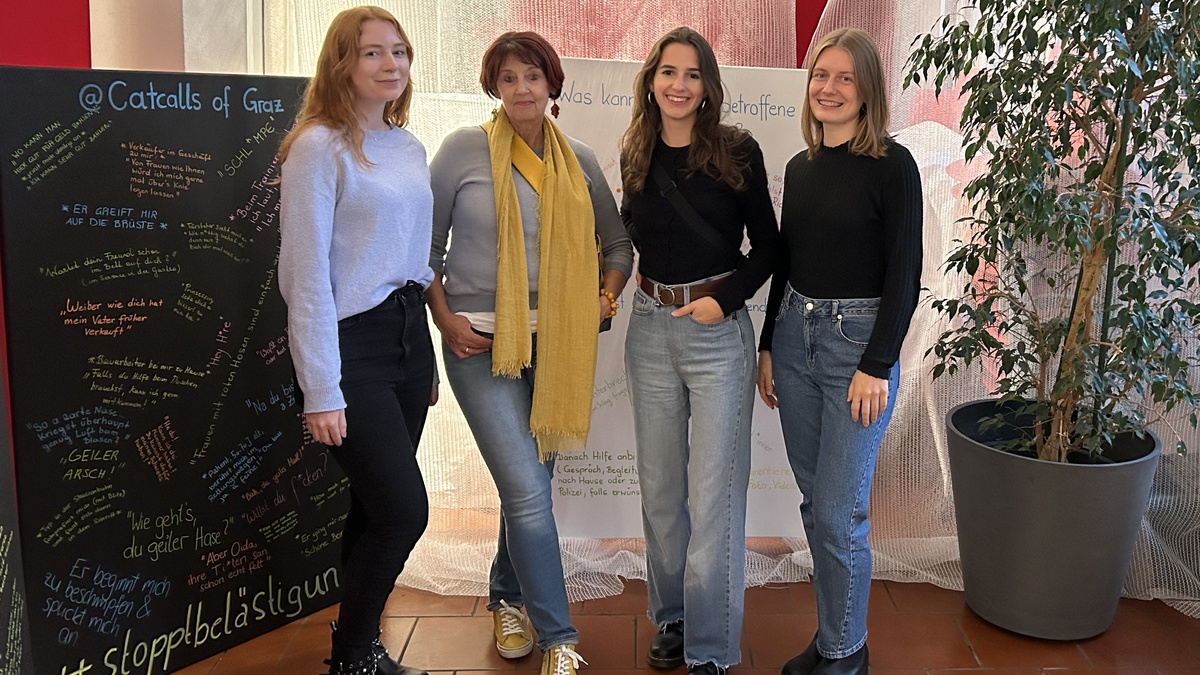 Eine Gruppe von Frauen vor bemalten Kreidetafeln.