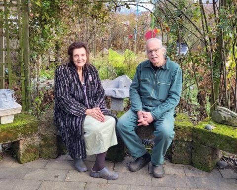 Irmie und Reinfried Horn sitzend vor ihrem Kunstgarten