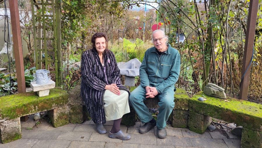 Irmie und Reinfried Horn sitzend vor ihrem Kunstgarten