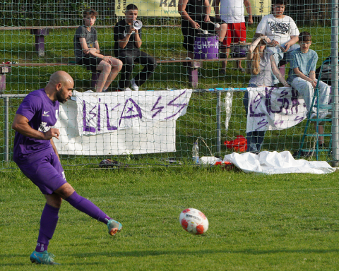 Karim Shafei beim Zuspiel. Er ist mitten in der Bewegung, hat den Ball erst vor wenigen Augenblicken getroffen. Im Hintergrund sieht man die Fans der Mannschaft mit Bannern, Trommel und Megafon.