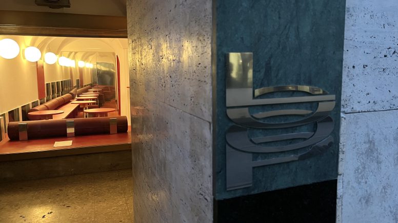 Das silberne "LOOP"-Logo prangt auf der bogenförmigen Fassade der Annenstraße 9. Im Hintergrund ist eine Auslage zu sehen.