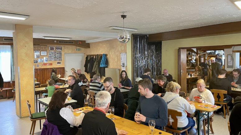 Gäste des Schnapsturniers sitzen im Gasthaus Fasching an den Tischen und spielen Karten