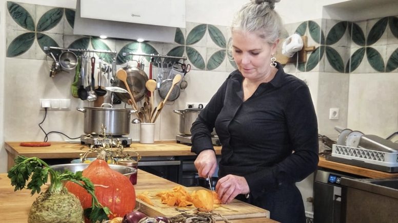 Christine schneidet Gemüse in ihrer Küche.