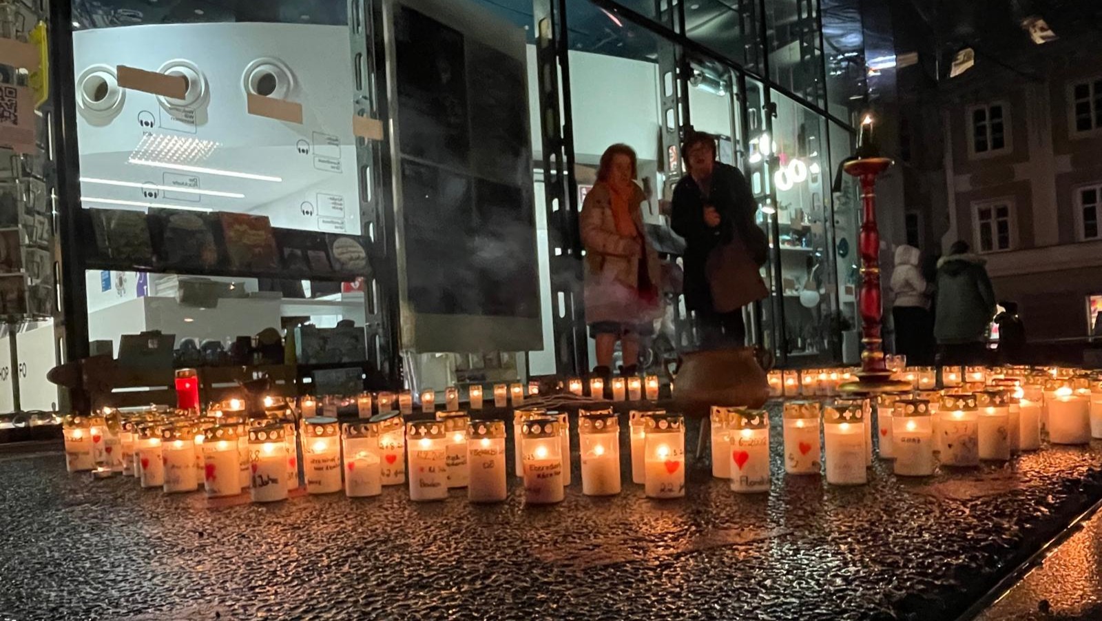 Auf dem Foto befindet sich ein Kreis aus Kerzen. Auf jeder Kerze steht Name und Alter eines Femizid-Opfers der letzten 5 Jahre