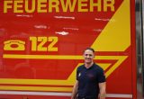 Löschmeister Markus Rechberger steht vor einem Feuerwehrfahrzeug