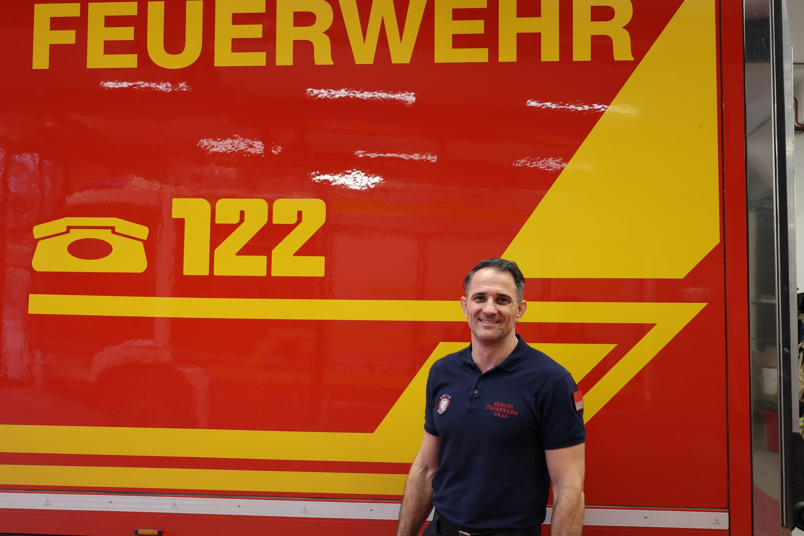 Löschmeister Markus Rechberger steht vor einem Feuerwehrfahrzeug