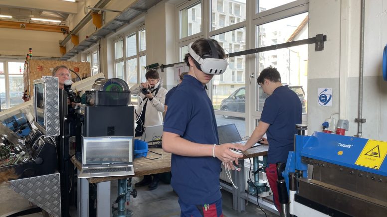 Ein Lehrling mit VR-Brille arbeitet in der Lehrwerkstätte