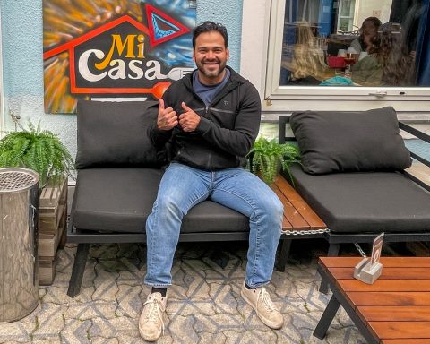 Mario Rosales Bados lächelnd auf einer Sitzgarnitur vor seinem Lokal Mi Casa