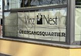 Im Fenster des Übergangsquartiers hängt ein Plakat mit der Aufschrift VinziNest.
