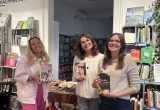 Julia Stobel, Martha Fromm und Laura Laubichler stellen den Besucher:innen Bücher der Autorin Isabel Allende vor.