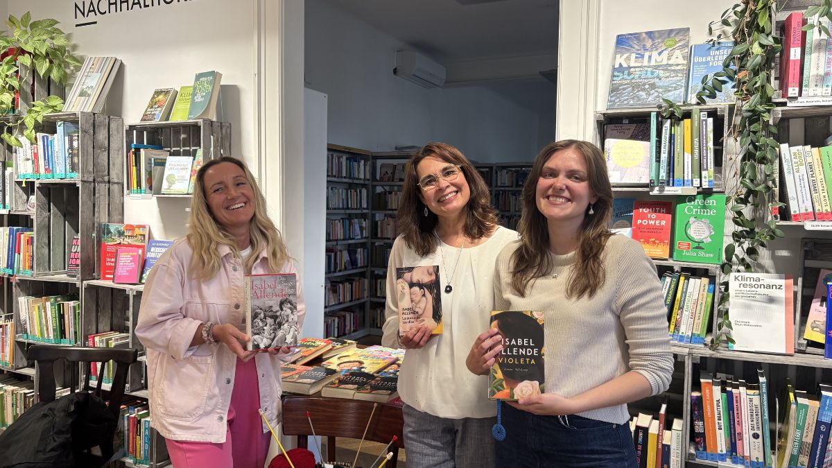 Julia Stobel, Martha Fromm und Laura Laubichler stellen den Besucher:innen Bücher der Autorin Isabel Allende vor.