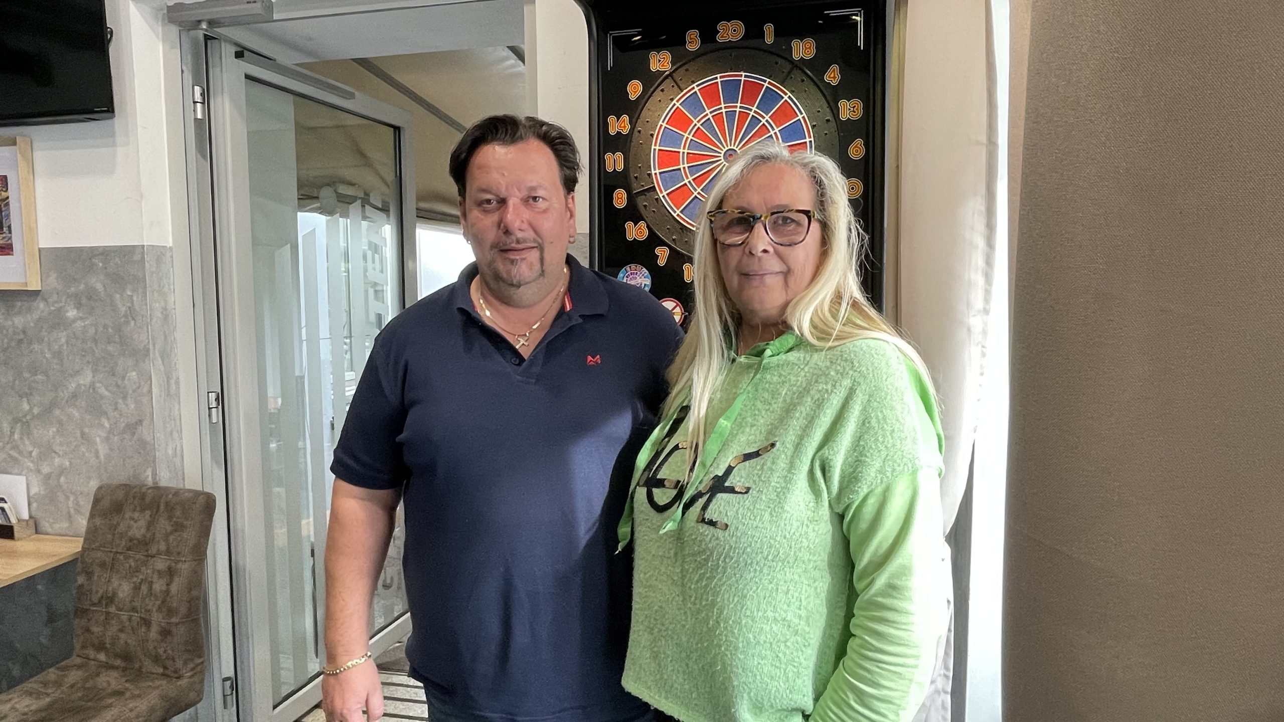 Maria und Roman Baranyai stehen vor dem Dart-Automaten im Cafe M&R