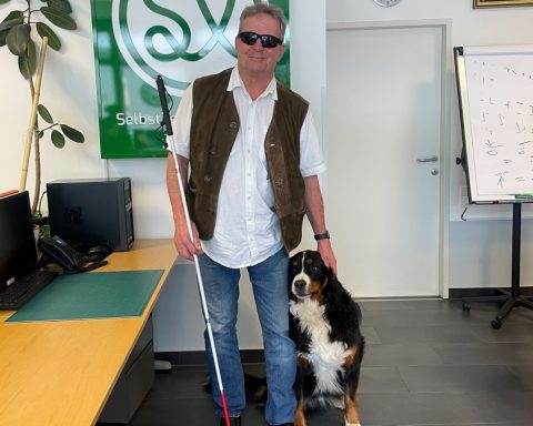 Dietmar Ogris, zusammen mit seinem Hund Bär, im Büro von "Selbstbestimmt Leben".