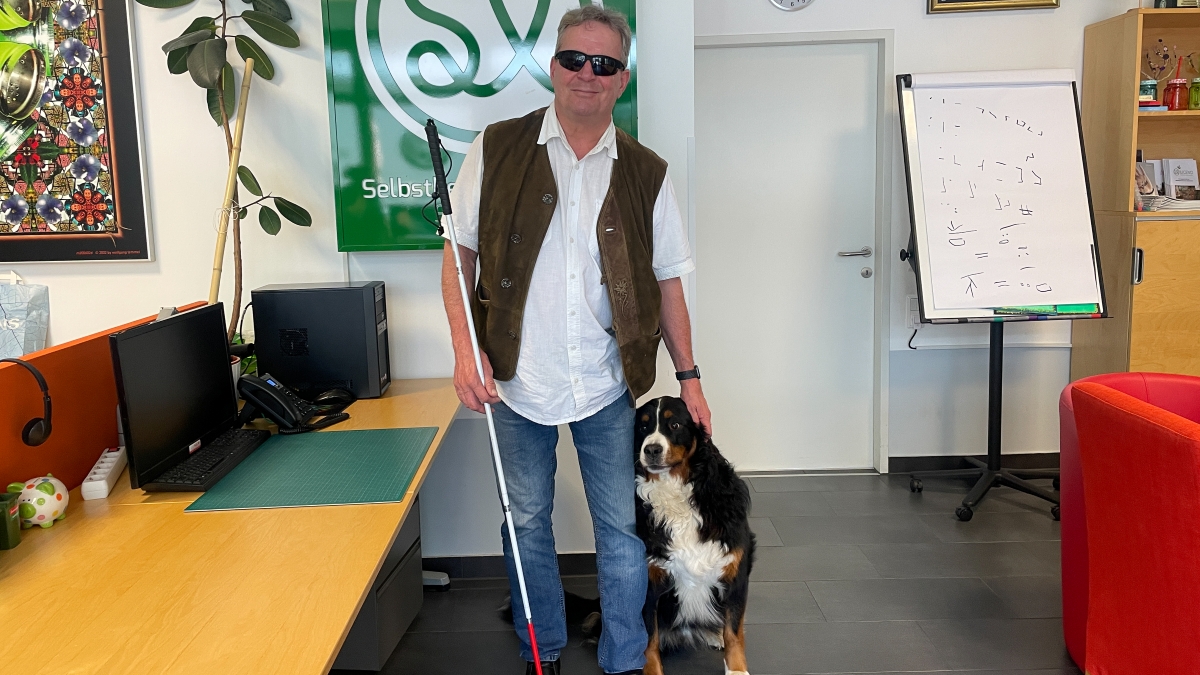 Dietmar Ogris, zusammen mit seinem Hund Bär, im Büro von "Selbstbestimmt Leben".
